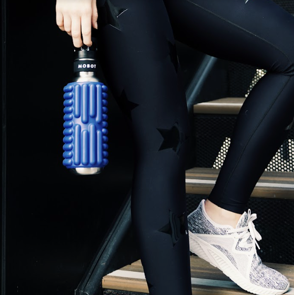 blue Mobot foam roller water bottle in the hand of an athlete 