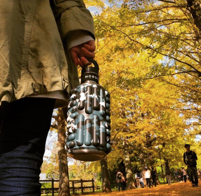 autumn walk in a park holding 40oz big bertha Mobot foam roller water bottle