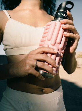 woman holding Mobot blush pink Grace foam roller water bottle 