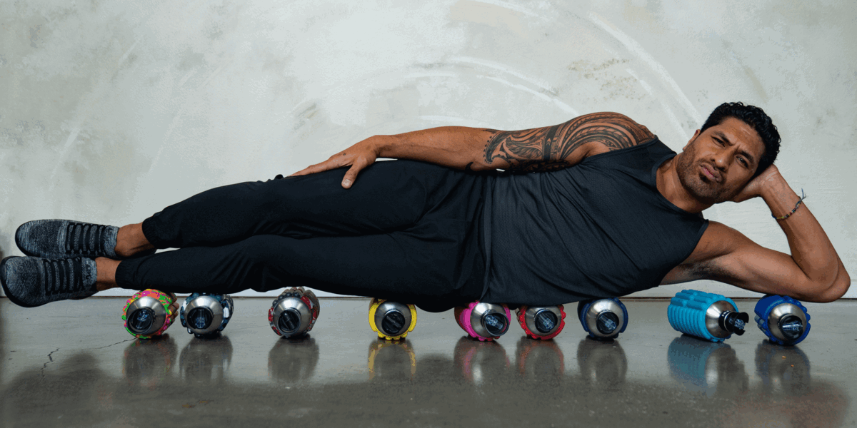 a man lying on 9 colorful Mobot Foam Roller Water Bottles 