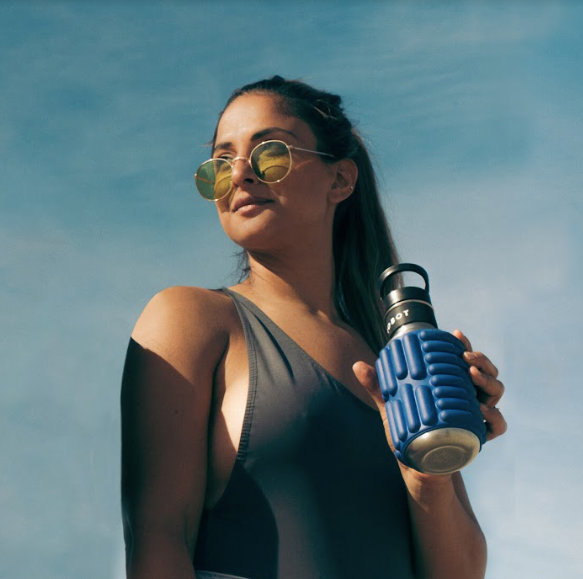a girl wearing glasses and holding blue 18oz firecracker Mobot foam roller water bottle