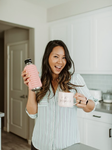 a lifestyle influencer holding her coffee mug and blush pink Mobot foam roller water bottle  