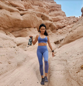 a model wearing blue sportswear and doing hiking with 27 oz Grace Mobot foam roller water bottle special ops