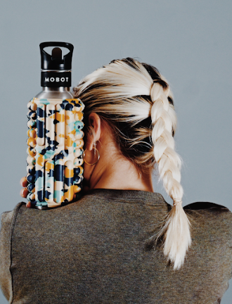 a blond woman honding colorful Big bertha 40oz Mobot foam roller water bottle 